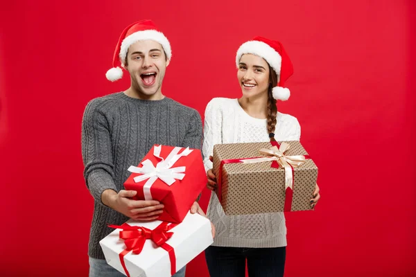 Conceito de Natal - Jovem casal atraente segurando um monte de presentes desfrutar de compras e celebrar no dia de Natal — Fotografia de Stock