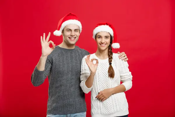 Conceito de Natal - retrato lindo jovem casal mostrando gesto ok com o dedo para câmera — Fotografia de Stock