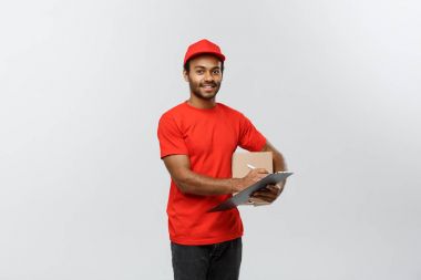 Teslimat kavramı - portre yakışıklı African American teslimat adam ya da kurye yazma bir siparişi belge üzerinde. Arka plan gri studio izole. Kopya alanı.