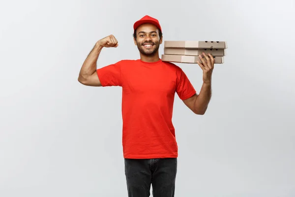Conceito de entrega - Retrato de homem de entrega afro-americano forte mostrando seu músculo com pacotes de caixa de pizza. Isolado no estúdio Grey Background. Espaço de cópia . — Fotografia de Stock