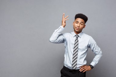 İş kavramı - gri arka plan üzerinde sinirli stresli Afrikalı-Amerikalı iş adamı portresi.