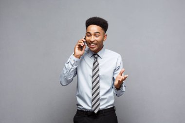İş kavramı - neşeli profesyonel Afrikalı-Amerikalı işadamı cep telefonu üzerinde müşteri ile konuşurken mutlu.