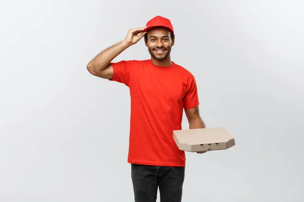 Lieferkonzept - Portrait des hübschen afroamerikanischen Pizzaboten. Isoliert auf grauem Studiohintergrund. Kopierraum. — Stockfoto