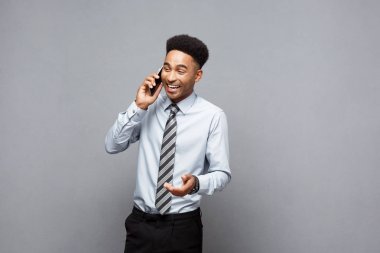İş kavramı - neşeli profesyonel Afrikalı-Amerikalı işadamı cep telefonu üzerinde müşteri ile konuşurken mutlu.