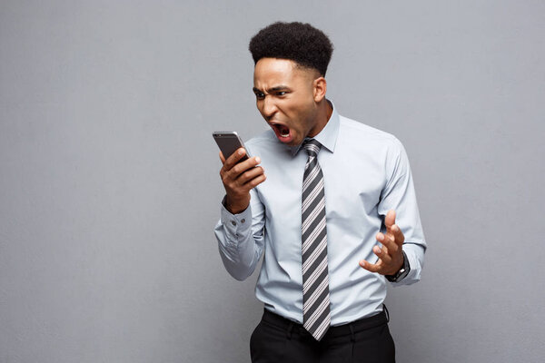 Бизнес-концепция - напряженный африканский бизнесмен кричит и кричит по мобильному телефону
.