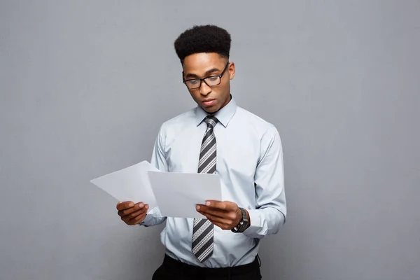 Affärsidé - stilig ung professionell afroamerikanska affärsman koncentrerad läsning på dokument papper. — Stockfoto