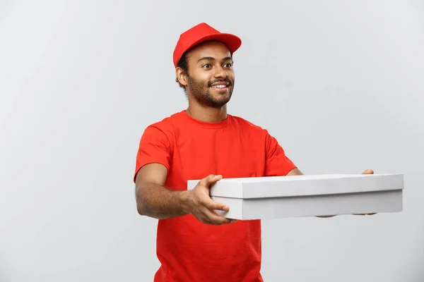 Conceito de entrega - Retrato de bonito afro-americano entregador de pizza. Isolado no estúdio Grey Background. Espaço de cópia . — Fotografia de Stock