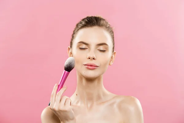 美容コンセプト - クローズ アップ美しい白人女性化粧品パウダー ブラシとメイクを適用します。完璧な肌。ピンクの背景とコピー領域に分離されました。. ロイヤリティフリーのストック写真