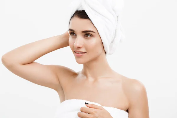 Ομορφιά και το δέρμα φροντίδα έννοια - όμορφη Καυκάσιος νεαρή γυναίκα με πετσέτα στο κεφάλι που καλύπτει το στήθος της, σε λευκό. — Φωτογραφία Αρχείου
