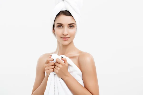 Ομορφιά και το δέρμα φροντίδα έννοια - όμορφη Καυκάσιος νεαρή γυναίκα με πετσέτα στο κεφάλι που καλύπτει το στήθος της, σε λευκό — Φωτογραφία Αρχείου