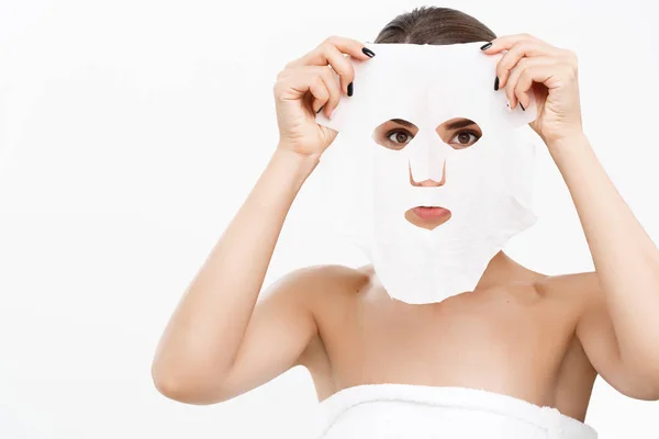 Krása kůže péče o koncept - krásná Kavkazský žena použití papíru list masku na její tvář bílé pozadí. — Stock fotografie