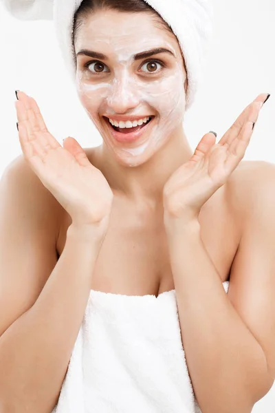Beauty Skin Care Concept - Retrato de rosto de mulher branca bonita aplicando máscara de creme em sua pele facial fundo branco . — Fotografia de Stock