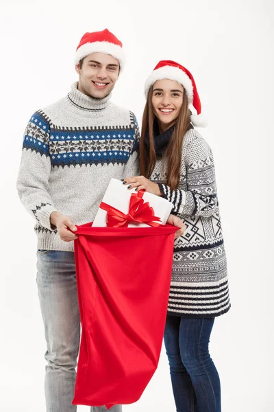 Concetto di Natale - giovane coppia attraente con la borsa rossa di Babbo Natale che celebra il giorno di Natale. Isolato su sfondo bianco — Foto Stock