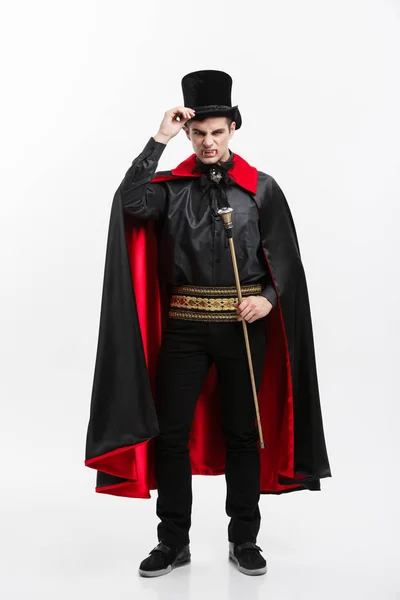 Conceito de Halloween de vampiro - Retrato de comprimento total de belo vampiro caucasiano em traje de Halloween preto e vermelho . — Fotografia de Stock