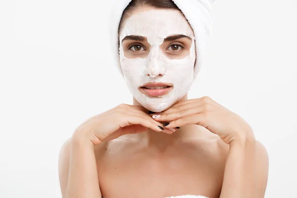 美容护肤理念-美丽的白种女人脸上的肖像应用奶油面膜在她的面部皮肤白色背景. — 图库照片