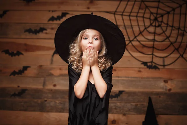 Koncepcja Halloween Witch - strzał zbliżenie małe dziecko kaukaski czarownica szokujące twarz pozowanie z bat i spider web na podłoże drewniane studio. — Zdjęcie stockowe