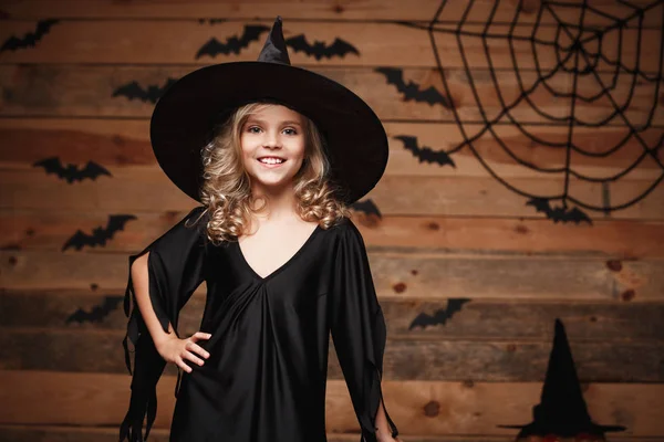 Halloween boszorkány koncepció - Vértes lövés pózol, mint bat és a spider web háttér kaukázusi boldog witch, kisgyermek.. — Stock Fotó