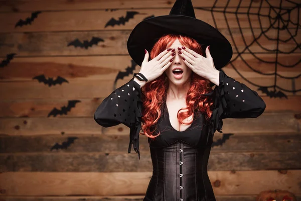 Halloween czarownica koncepcja - Happy Halloween czerwone włosy czarownicy, trzymając się za ręce zamknięcia oczu pozowanie na stare drewniane studio tło. — Zdjęcie stockowe