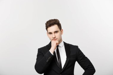 İş kavramı: Çeneme elini tutarak, gri arka plan üzerinde duran ve ciddi yan görünümlü yakışıklı emin düşünceli insanın kopya alanı portre