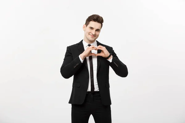 Business Concept: Portrait of charming attractive businessman holding hands in heart gesture and lifting eyebrows while smiling, isolated over white grey background. — Stock Photo, Image