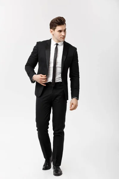 Business Concept: Ritratto a figura intera di un elegante uomo d'affari in abito elegante che cammina su sfondo bianco . — Foto Stock