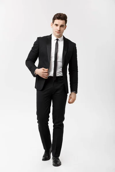 Business Concept: Full lengde portrettbilde av en elegant forretningsmann i smart dress som går på hvit bakgrunn . – stockfoto