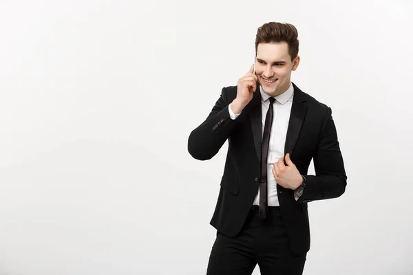 Business Concept: Portrait of a cheerful businessman in smart suit talking on the smart phone isolated on a white background — Stock Photo, Image