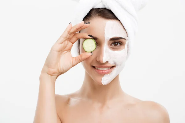 Beauty Youth Skin Care Concept - Portrait Beautiful Caucasian Woman apply cream and holding fresh cucumber in front of her face.Isolated over white background. — Stok Foto