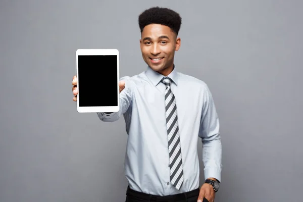 商业理念-快乐英俊的专业非洲裔美国商人向客户展示数码平板电脑. — 图库照片