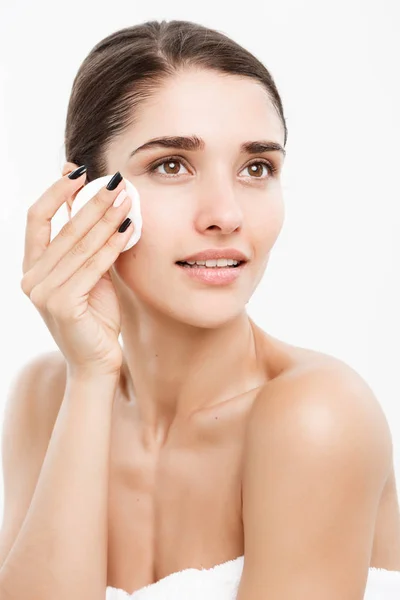 Krása kůže péče o koncept - krásná žena čištění její tvář s vatovým tamponem - nad bílým pozadím a usmívá se. — Stock fotografie