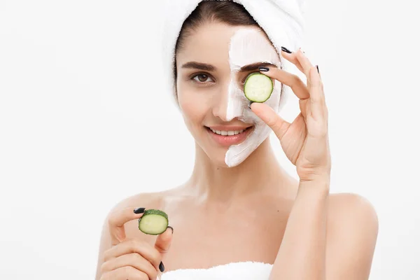 Beauty Youth Skin Care Concept - Portrait Beautiful Caucasian Woman apply cream and holding fresh cucumber in front of her face.Isolated over white background. — Stok Foto