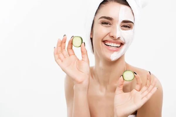 Beauty Youth Skin Care Concept - Portrait Beautiful Caucasian Woman apply cream and holding fresh cucumber in front of her face.Isolated over white background. — Stok Foto