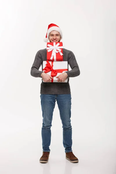 Christmas koncept - lycklig ung man med skägg bär en hel del presenter isolerad på vit bakgrund. — Stockfoto
