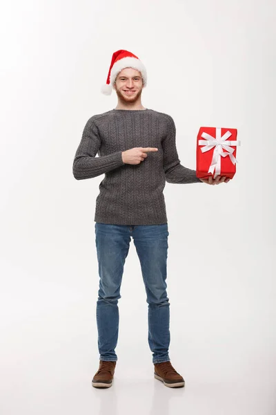 Conceito de Natal - Jovem feliz com barba apontando dedo presente isolado no fundo branco . — Fotografia de Stock