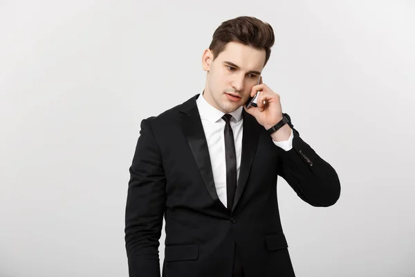 Business Concept: Portrait of young handsome businessman talking on mobile phone with serious and stress expression. Isolated over white background. — Stock Photo, Image