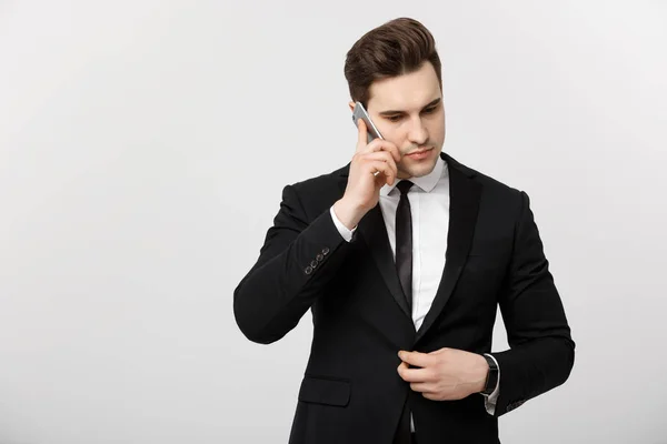 Conceito de Negócios: Retrato de jovem empresário bonito falando no celular com expressão séria e estressante. Isolado sobre fundo branco . — Fotografia de Stock
