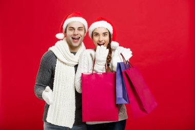 Noel kavramı - alışveriş çantası tutan genç çekici çift alışveriş ve Noel günü kutlamanın keyfini çıkarın
