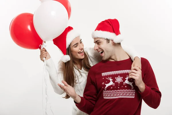 Conceito de Natal - Jovem namorada segurando balão está abraçando e brincando com seu namorado fazendo uma surpresa no Natal — Fotografia de Stock