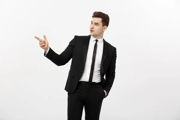 Business Concept: Close up portrait of young successful brunete stock-market broker guy or businessman pointing on a copyspace with his finger on white background. — Stock Photo, Image