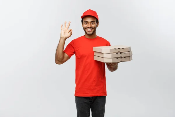 Koncepcja dostawy - portret przystojny African American Pizza dostawa człowieka co ok znak palcami. Na białym tle na studio szary tło. Miejsce. — Zdjęcie stockowe