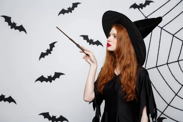 Halloween koncepció - gyönyörű boszorkány játék a magic kibír a szürke háttér. — Stock Fotó