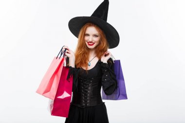 Halloween cadı kavramı - mutlu Cadılar Bayramı gülümseyen ve beyaz arka plan üzerinde renkli alışveriş torbaları tutan cadı.