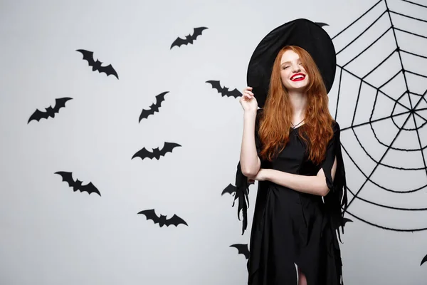 ハロウィン魔女コンセプト - 幸せなハロウィーン魔女コウモリ、クモの web と暗い灰色スタジオ背景にポーズを保持しています。. — ストック写真