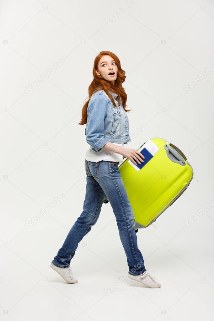 Travel Concept: Young Caucasian Woman traveler with suitcase isolated on white background.