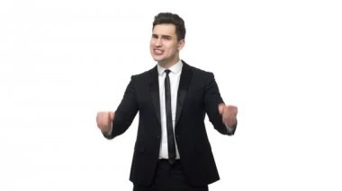 Ağır çekim yakışıklı genç işadamı başarılı başarı hakkında zafer jest yapıyor. Beyaz gri arka plan üzerinde izole.