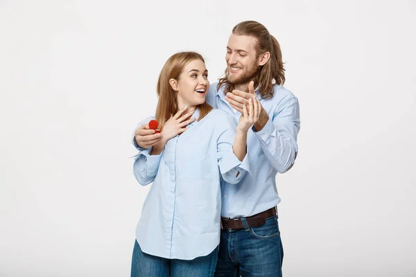 Concepto de propuesta - Retrato del hombre mostrando un diamante anillo de compromiso a su novia beutiful sobre fondo blanco aislado . —  Fotos de Stock