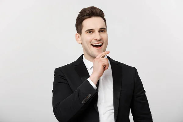Concepto de Negocio: Sonriente hombre guapo reflexivo de pie sobre fondo blanco aislado y tocándose la barbilla con la mano — Foto de Stock
