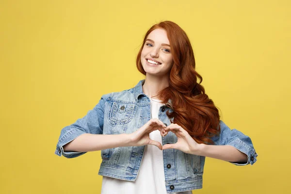 Concepto de estilo de vida: Hermosa mujer atractiva en denim haciendo un símbolo del corazón con sus manos —  Fotos de Stock