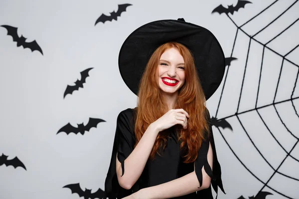 Halloween Concept - mooie heks die hand en lachend over grijze achtergrond. — Stockfoto