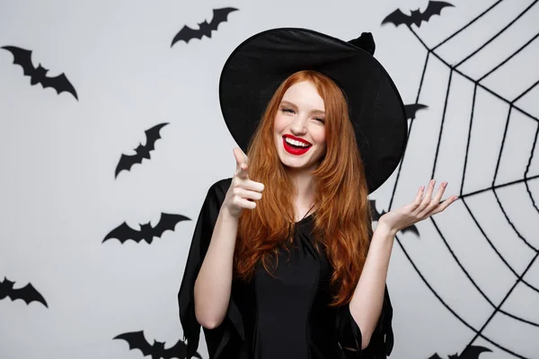 Halloween boszorkány koncepció - Happy Halloween boszorkány ujját a sötét szürke stúdió háttere, a denevér és a spider web oldalról. — Stock Fotó